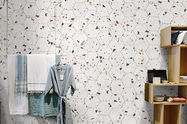 Keramische wandtegels en vloertegels in terrazzo look wit met blauw, oranje, oker.