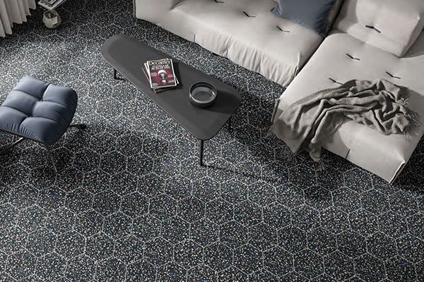 Woonkamer met zwarte hexagon tegels in felle kleuren.