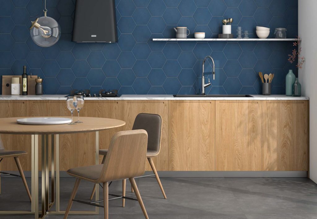 Spatwand in de keuken met blauwe hexagonale tegels zowel voor de vloer als de wand.