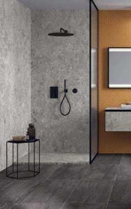 Douche met keramische ceppo in XXL tegels of keramische platen. De badkamer vloer is geplaatst in donker grijze tegels en als wand achter de wasbak werd voor oker hexagon mozaïek gekozen.