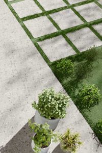 Licht grijze keramische terrastegels in ceppo look 60x60x2cm als stapstenen in het gras en terras.