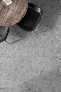 Woonkamer met grote grijze ceppo di gre vloertegels in een landelijk interieur