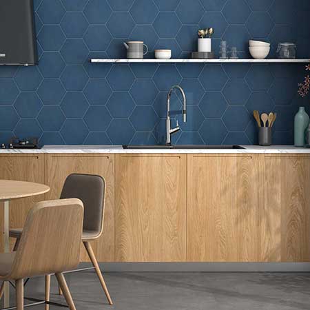 Moderne keuken in warme eik met marine blauwe hexagon tegels als keukenwand.