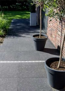 Keramische terrastegels in donker blauwsteen look met fossielen. Formaat 60x60x2cm