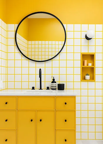 Witte wandtegels met opvallende gele voegen geven deze budgetvriendelijke badkamer een trendy en vrolijke uitstraling. Ideaal voor wie met een klein budget een groot effect wil creëren.