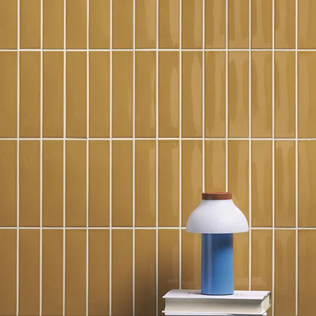 Blinkende oker tegels in 5x20 cm brengen dit retro interieur tot leven met warme mediterrane tinten. De glans en kleur zorgen voor een speelse, zonnige uitstraling. Ideaal voor wie op zoek is naar een warme retro badkamer, keuken of toilet.