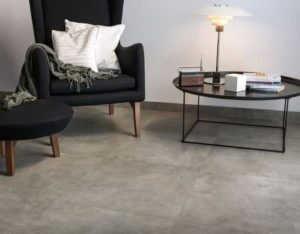Woonkamer met grijze betonlook tegels die er uit zien als gepolierde beton.