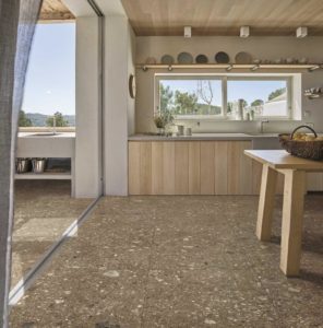 Landelijke keuken met beige keramische ceppo di gres tegels op de vloer in combinatie met beige muren en meubels in warm hout.