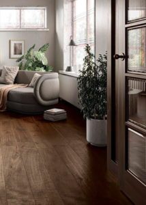 Landelijk moderne woonkamer met als vloer keramisch parket in donker eik rood hout.