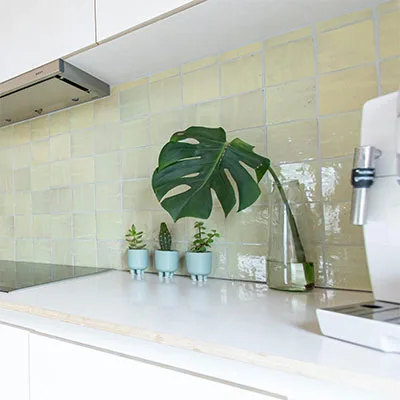 In deze tijdloze keuken werd er voor gekozen om pastel groene zelliges aan de spatwand te plaatsen. Hier met een witte voeg.