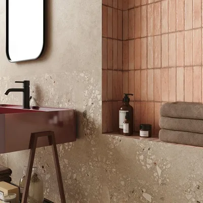 Roze wandtegels met terrazzo tegels als nis in de badkamer.