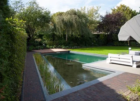 Tuinpad en zwembadomgeving afgewerkt met onderhoudsvriendelijke kleiklinkers. Deze kleurvaste, slijtvaste gebakken klinkers zijn ideaal rond het zwembad en in de tuin, omdat ze weinig onderhoud vragen en hun uitstraling behouden. Inspiratie en advies bij Top Tegel 04 in Ieper, West-Vlaanderen.