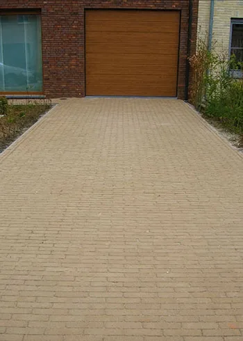 Tijdloze oprit aangelegd met zandkleurige, beige kleiklinkers. Deze gebakken klinkers zorgen voor een rustige en warme uitstraling en zijn tegelijk kleurvast, slijtvast en geschikt voor dagelijks gebruik. Ontdek duurzame kleiklinkers met advies bij Top Tegel 04 in Ieper, West-Vlaanderen.
