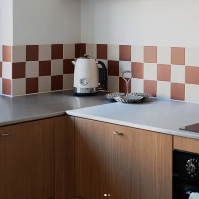 Keuken met dambord tegels 10x10 in terracotta en wit als spatwand, retro wandtegels van Winckelmans, Pavigres en Topcer, ideaal voor een warme vintage uitstraling